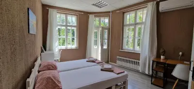 a bedroom with a white bed and windows at Lambo's Corner Varna - Guest Rooms in Varna City