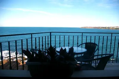 a balcony with a table and chairs and the ocean at Sea View Apartments in Sozopol