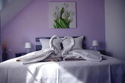 a white bed with a pile of towels on it at Sea View Apartments in Sozopol