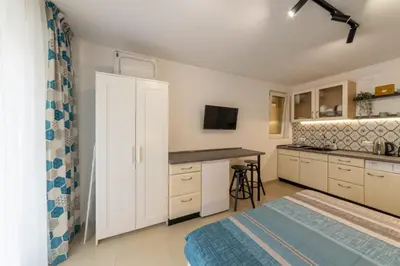 a bedroom with a bed and a kitchen with a counter at Roman Thermae Central Studio in Varna City
