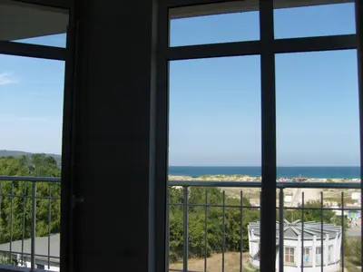 a room with a window looking out at the ocean at Kirovi Apartment in Primorsko