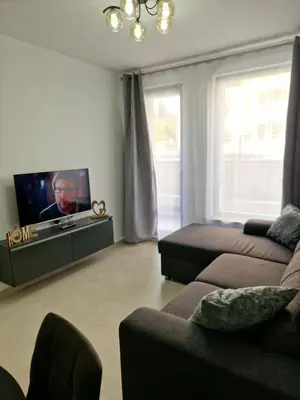 a living room with a couch and a flat screen tv at Polarstar 2-Zimmer Appartements in Sveti Vlas