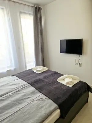 a bedroom with a bed with a flat screen tv on the wall at Polarstar 2-Zimmer Appartements in Sveti Vlas
