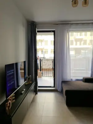 a room with a bed and a television and a window at Polarstar 2-Zimmer Appartements in Sveti Vlas
