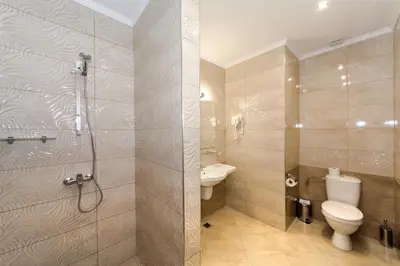 a bathroom with a shower and a toilet and a sink at Hotel Venus in Sunny Beach