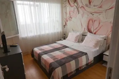a bedroom with a bed with a floral wall at Magnolia in Burgas City