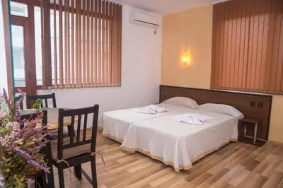 a hotel room with a bed and a table and chairs at Chrystal Guest House in Obzor