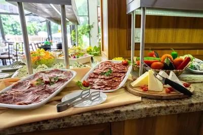 a buffet with meat and vegetables on a table at Izola Paradise Hotel - All Inclusive in Sunny Beach
