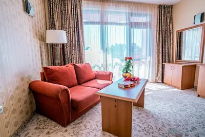 a living room with a red couch and a table at Izola Paradise Hotel - All Inclusive in Sunny Beach
