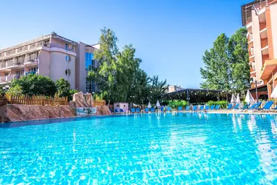 a swimming pool at a hotel with blue chairs at Izola Paradise Hotel - All Inclusive in Sunny Beach