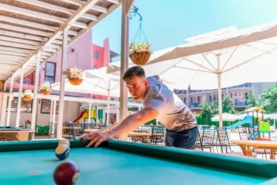 a man playing pool at a pool table at Izola Paradise Hotel - All Inclusive in Sunny Beach
