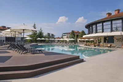 a swimming pool with chairs and umbrellas in a resort at Marina Hills in Sozopol
