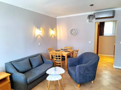 a living room with two blue chairs and a table at Marina Hills in Sozopol