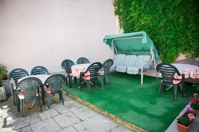 a group of chairs and tables on a green lawn at Стаи за гости in Varna City