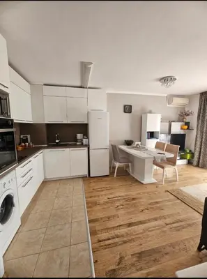 a kitchen with white appliances and a table in it at Прекрасные апартаменты с видом на море в центре in Byala