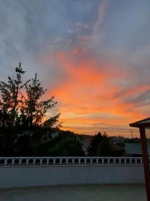 a sunset over a white fence with a sky at Прекрасные апартаменты с видом на море в центре in Byala