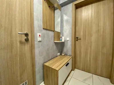 a bathroom with a toilet and a wooden door at AVRORA SUITE in Varna City