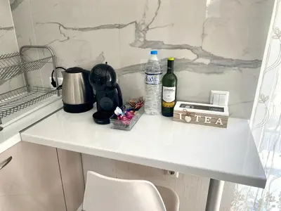 a white kitchen counter with bottles of wine and a blender at AVRORA SUITE in Varna City