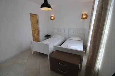 a bedroom with two beds and a desk and a mirror at Flores Garden - Menada Apartments in Chernomorets