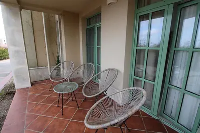 a group of chairs and tables on a porch at Flores Garden - Menada Apartments in Chernomorets
