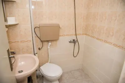 a bathroom with a toilet and a shower and a sink at Hotel Relax in Varna City