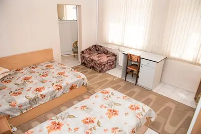 a small bedroom with two beds and a desk at Hotel Relax in Varna City