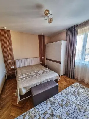 a bedroom with two beds and a bench in it at Sea Light in Burgas City