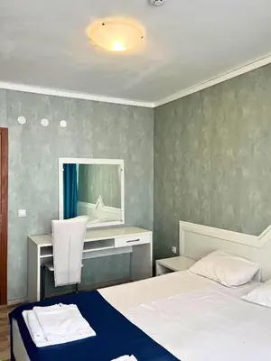 a bedroom with two beds and a desk and a mirror at STELA in Nesebar