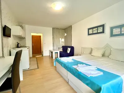 a bedroom with a bed with a blue blanket at STELA in Nesebar