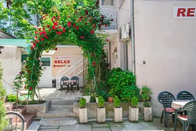 an outdoor patio with tables and chairs and flowers at Стаи за гости in Varna City