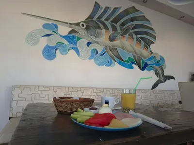 a plate of food on a table with a fish on the wall at Guest House Compass in Lozenets