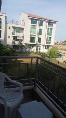 a balcony with two white chairs and a building at Guest House Compass in Lozenets