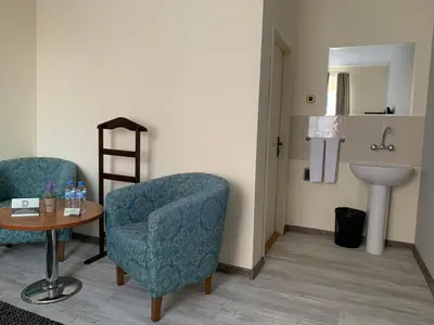 a waiting room with a chair and a sink at Guest Rooms Donovi in Varna City