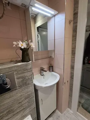 a bathroom with a sink and a vase of flowers at Sea Time Burgas1 in Burgas City