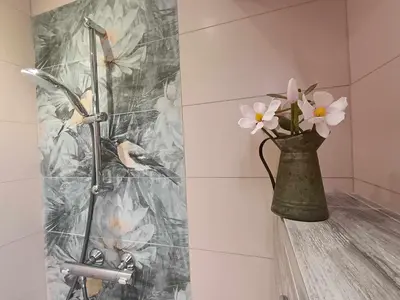 a vase of flowers sitting on a shelf in a bathroom at Sea Time Burgas1 in Burgas City