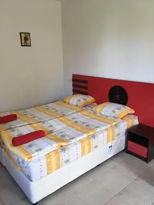 a bedroom with a large bed with a red headboard at Zapovedni Rai in Primorsko