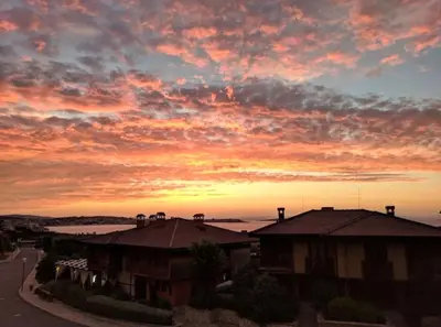 a sunset over roofs of houses in a city at Sozopol Созопол- SOZOPOLIS -MORE SUN 2А- in Sozopol