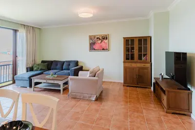 a living room with a blue couch and a table at Sozopol Созопол- SOZOPOLIS -MORE SUN 2А- in Sozopol