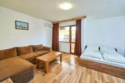 a living room with a couch and a bed at Hotel Koral in Primorsko