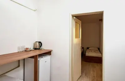 a kitchen with a counter and a room with a bed at Hotel Koral in Primorsko
