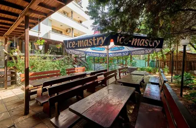 a group of wooden benches sitting outside of a building at Hotel Koral in Primorsko