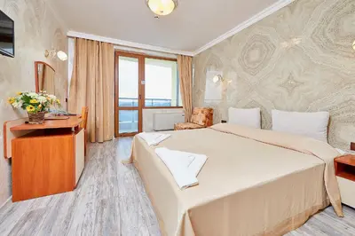 a hotel room with a large bed and a table at Petar and Pavel Hotel & Relax Center in Pomorie