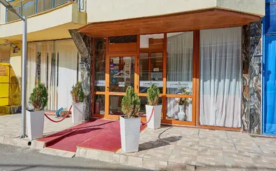 a store front with potted plants in front of it at Petar and Pavel Hotel & Relax Center in Pomorie