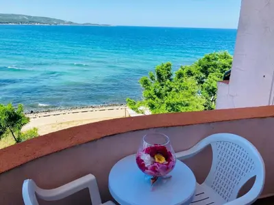 a glass vase sitting on a table with a view of the ocean at Plovdiv Hotel in Primorsko
