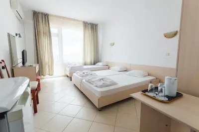 a hotel room with two beds and a sink at Plovdiv Hotel in Primorsko