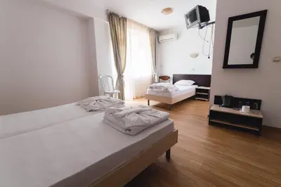 a hotel room with two beds and a mirror at Plovdiv Hotel in Primorsko
