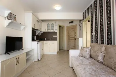 a living room with a couch and a kitchen at Villa Livia Boutique Apartments in Ravda
