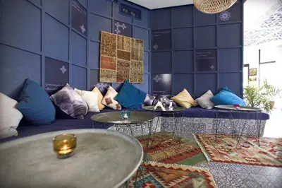 a room with a blue couch with pillows and tables at Villa Livia Boutique Apartments in Ravda