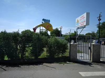 a fence with a monkey jumping over a hedge at Camping Goldfish in Sozopol