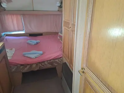 a small bed in a small room with pink sheets at Camping Goldfish in Sozopol